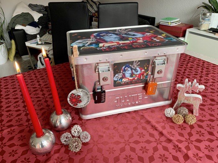 Beat the Red Box Koffer mit roten Kerzen und Weihnachtsdeko auf festlich gedecktem Tisch